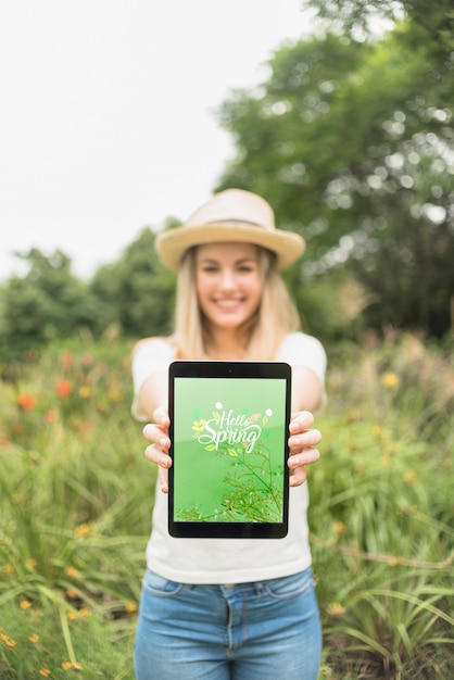 Download Woman presenting tablet mockup in nature | Free PSD File PSD Mockup Templates