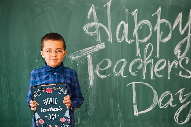 World teacher day mockup with kid holding clipboard PSD Template