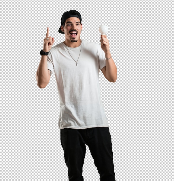 Young rapper man cheerful and excited, pointing upwards, holding a light bulb as a symbol of idea, imagination, mental fluidity and wisdom, inspirational photo Premium Psd