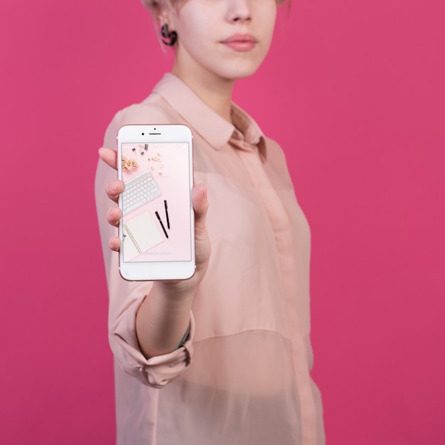 Download Young woman holding smartphone mockup | Free PSD File