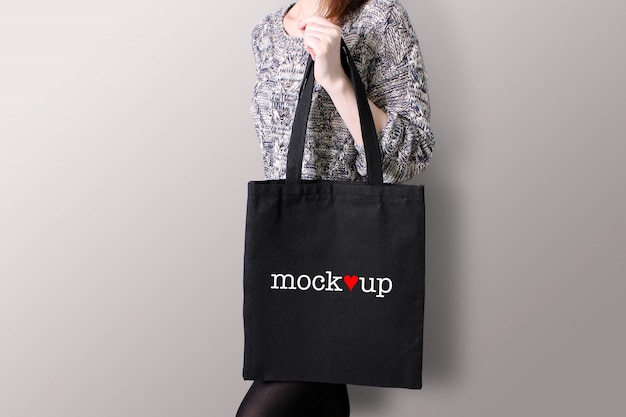 Download Young woman is holding a black tote bag, mockup. | Premium ...