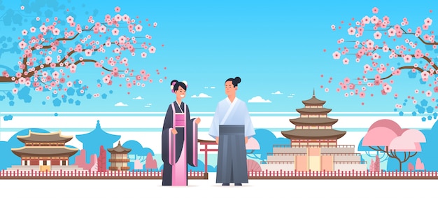 塔の建物の風景の上に中国語または日本語の文字を一緒に立っている古代の衣装で伝統的な服の男性女性を着ているアジアカップル プレミアムベクター