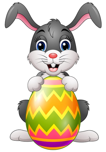 Cartoon bunny holding easter egg | Premium Vector