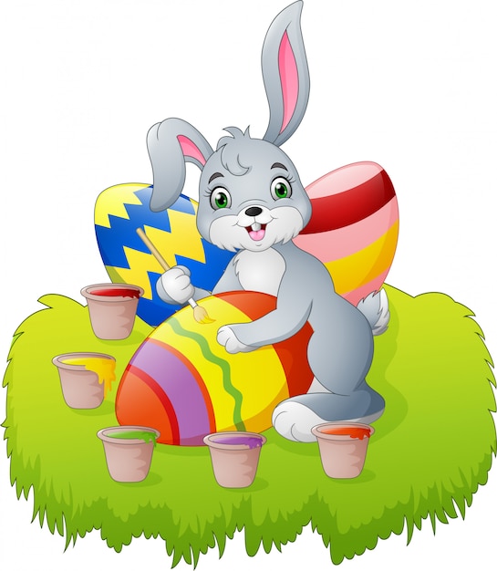 Download Premium Vector | Cartoon easter bunny painting an egg