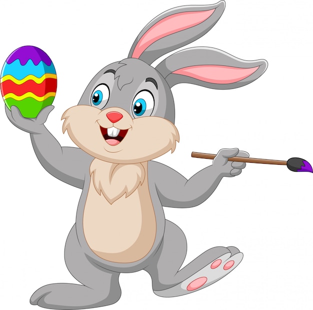 Premium Vector | Cartoon rabbit painting an easter egg