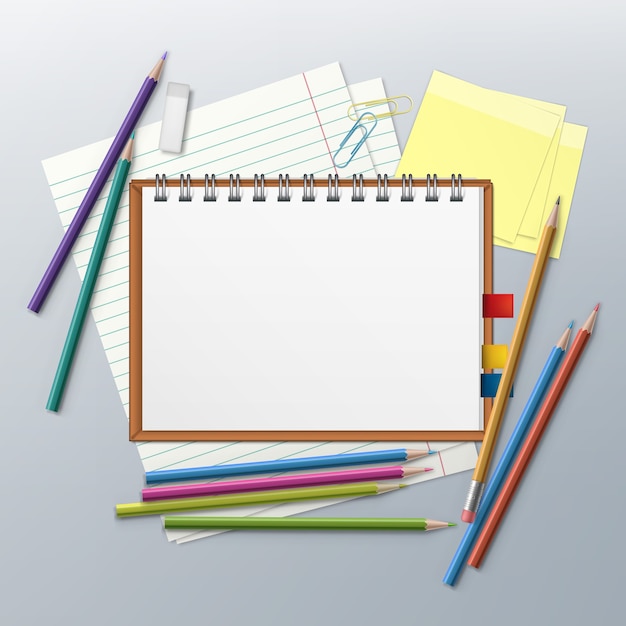 メモ帳、クリップ、紙のシート、テキスト用のスペースが付いた色鉛筆 Premiumベクター