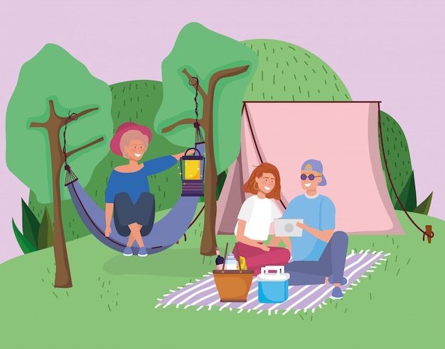 Couple with tablet blanket and woman in hammock tent ...