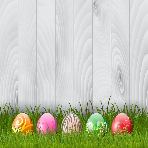 Free Vector Decorative Easter Eggs In Grass On A Wood Background