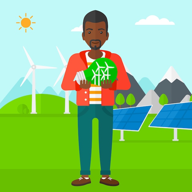 Man holding lightbulb with windmills inside Premium Vector