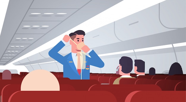 Steward explaining for passengers how to use oxygen mask ...