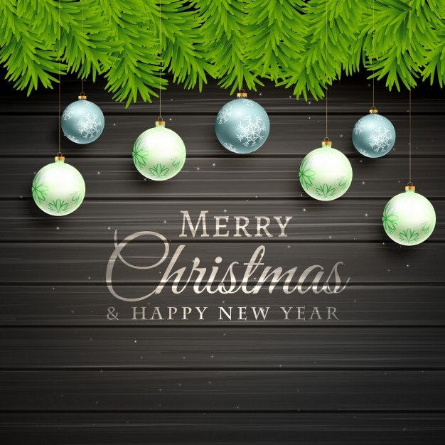 Wooden background with balls ornaments and fir\
leaves