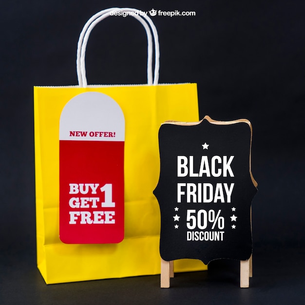 Download Black friday mockup mit tasche neben board | Kostenlose PSD-Datei