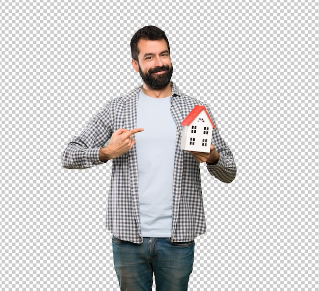Gut aussehender mann mit dem bart, der ein kleines haus hält Premium PSD