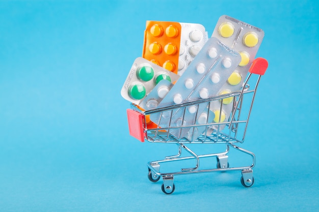 Acheter des médicaments, des frais de santé et des médicaments sur ordonnance avec un caddie rempli de pilules Photo Premium