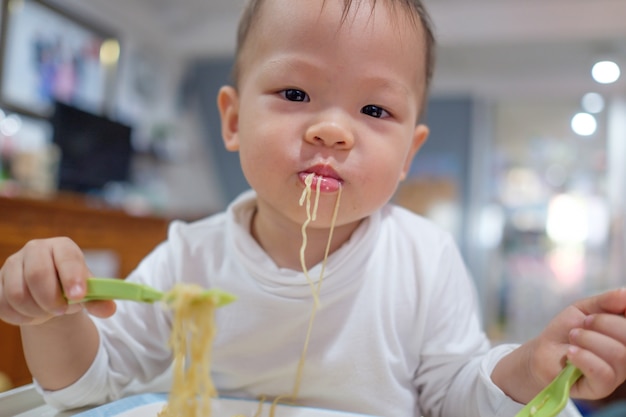 Adorable Petit Enfant De Garcon De Bebe Asiatique Asiatique Age D Un An Mange Des Nouilles Avec Une Fourchette Photo Premium