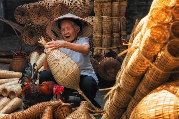 Ancienne artisan vietnamienne faisant le traditionnel 