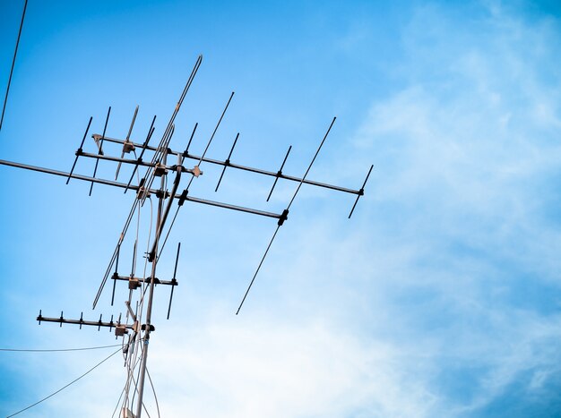 Ancienne transmission du signal d'antenne de télévision sur bleu ciel. ancienne technologie de communication télévisée. Photo Premium