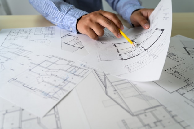 Architectes travaillant sur un ordinateur portable à l'intérieur d'un lieu de travail d'architecte Photo Premium