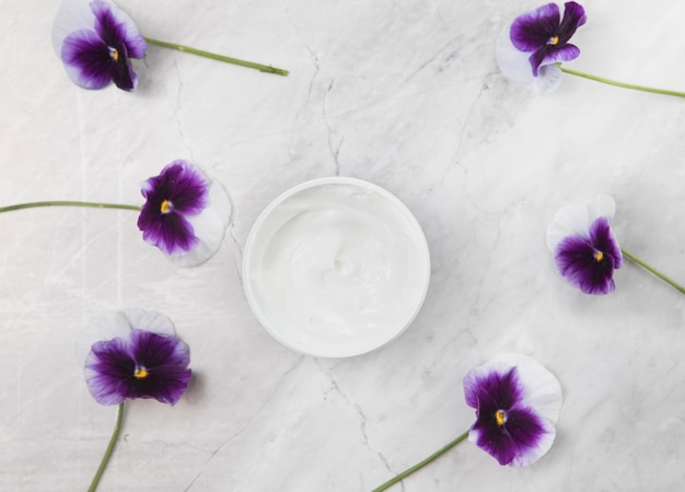 Arrangement de crème pour le corps sur fond de marbre Photo gratuit