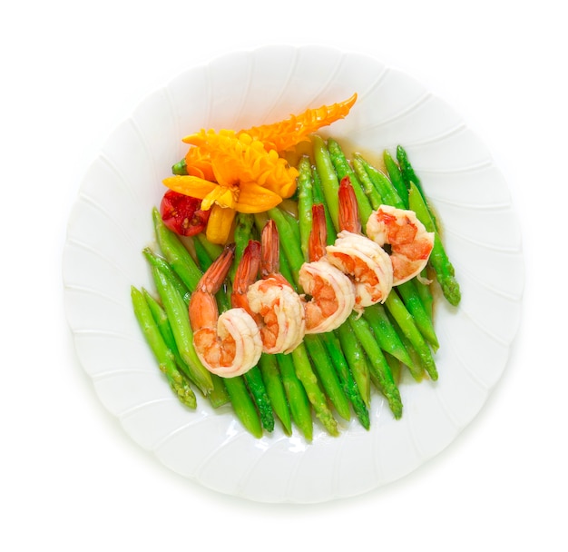 Asperges sautées aux crevettes décorer une vue de dessus de piment jaune et de tomates sculptées Photo Premium