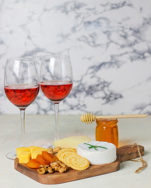 Assiette de fromages, camembert, romarin, craquelins, abricots secs et noix Photo gratuit
