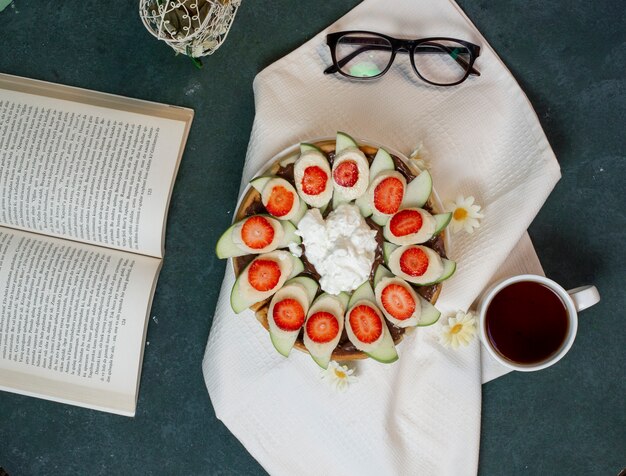 Une Assiette De Gaufres Avec Des Fruits Et Des Glaces Et Une Tasse De Thé. Vue De Dessus. Photo gratuit