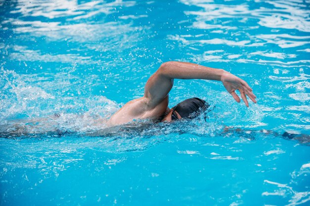 Athletique Jeune Homme Nageant Le Crawl Dans Une Piscine Competition De Natation Photo Premium