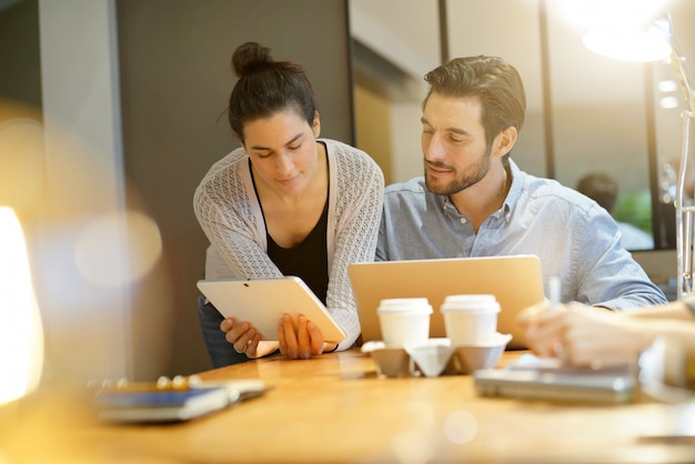Attrayants collègues partageant des idées d’entreprise dans un espace de travail commun Photo Premium