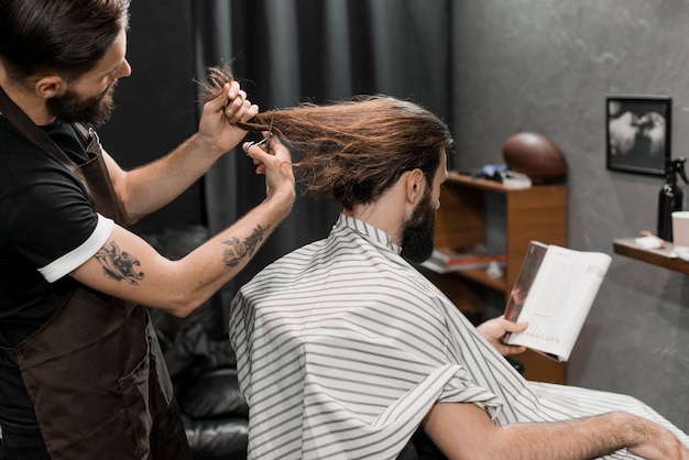 Barber Coupe Les Cheveux Longs De L Homme Dans Un Salon De