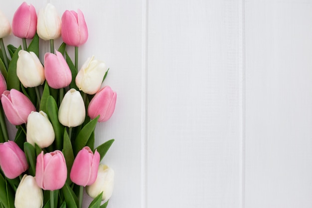 Beau bouquet de tulipes sur un fond en bois blanc avec 