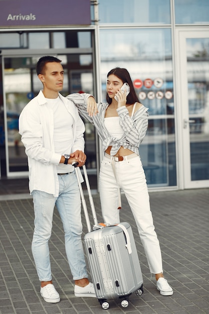 Beau couple debout près de l'aéroport Photo gratuit