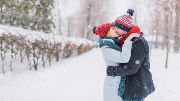 Beau Couple Sembrassant Dans La Neige Photo Gratuite