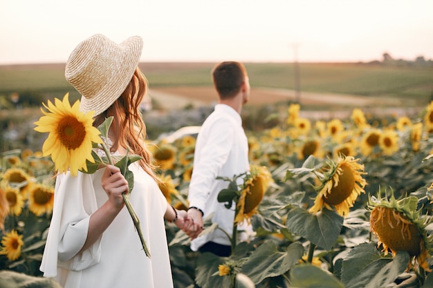 Beau et élégant couple dans un champ de tournesols Photo gratuit