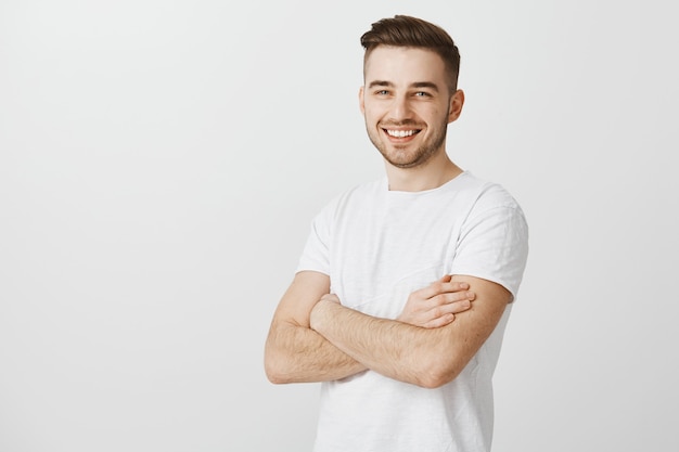 Beau Jeune Homme En T Shirt Blanc Poitrine De Bras Croises Et Souriant Heureux Photo Gratuite