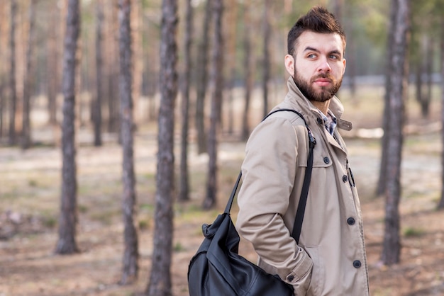 Beau voyageur mâle avec sac à dos sur son épaule à la recherche de suite Photo gratuit