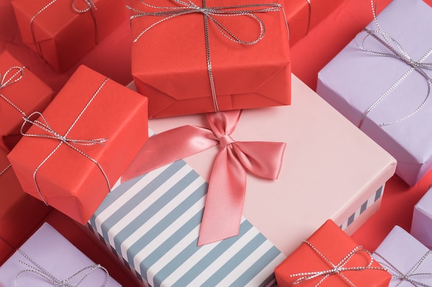 Beaucoup de petits cadeaux mixtes emballés dans du papier rouge et lilas Photo Premium