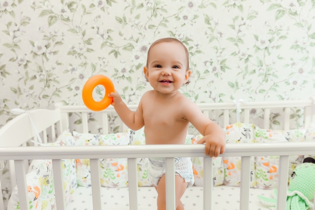 Un Bebe De 11 Mois Dans Une Couche Se Tient Dans Son Lit D Enfant Dans Le Lit Photo Premium