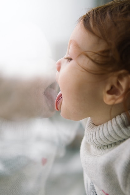 Bebe D Un An Petite Fille Assise Sur La Fenetre Dans Une Piece Enfants Lechant Le Verre Photo Premium