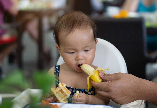 Bebe Asiatique Mignon Bebe Fille Manger Une Banane Photo Premium