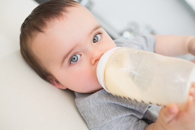 Bebe Buvant Du Lait En Position Couchee Sur Le Comptoir Photo Premium