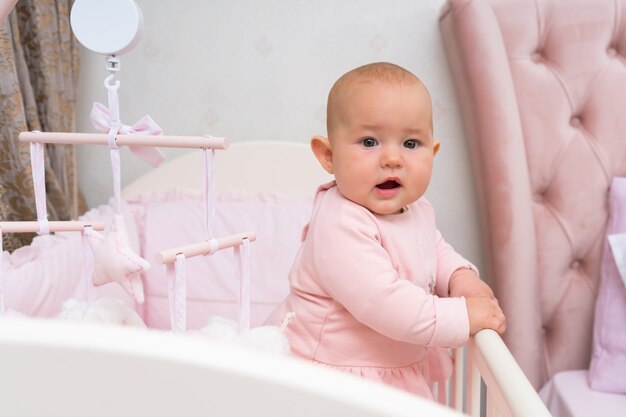 Un Bebe Dans Un Berceau Et Une Scene De Chambre Rose Avec Un Mobile Suspendu Photo Premium