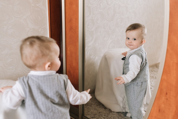 Bebe De Dix Mois Se Tient Devant Le Miroir Et Joue Avec Lui Meme Photo Premium