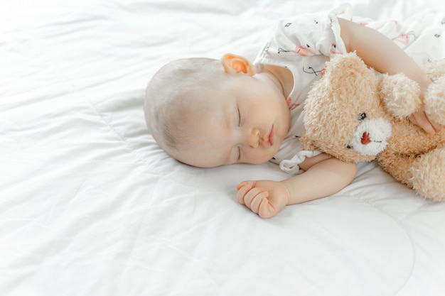 Bebe Dort Avec Un Ours En Peluche Photo Gratuite