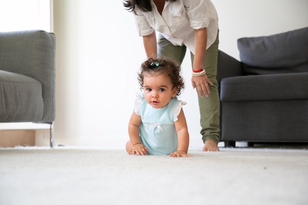 Bebe Drole Mignon Rampant Sur Le Sol A La Maison Maman Debout Derriere Le Petit Enfant Concept De Parentalite Et D Enfance Photo Gratuite