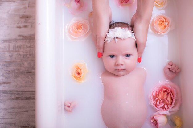 Bebe Fille Enfant Ayant Un Bain De Lait Avec Des Fleurs Roses Photo Premium