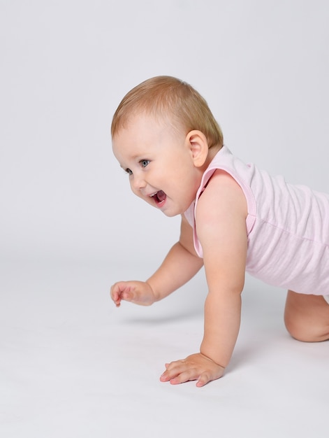 Un Bebe Sur Fond Blanc Apprend A Ramper Les Premiers Pas De Bebe Photo Premium