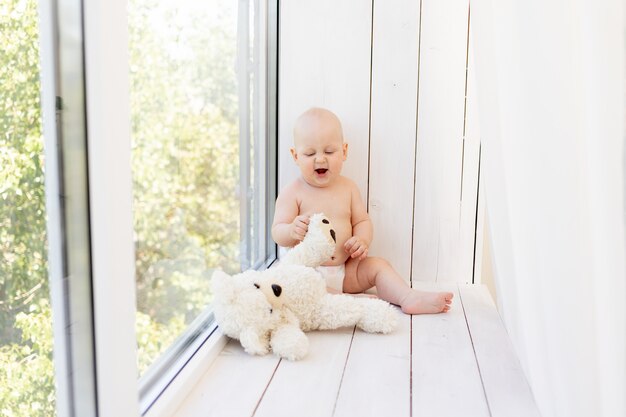 Bebe Garcon De 8 Mois Couche Dans Des Couches Sur Un Lit Blanc Avec Une Bouteille