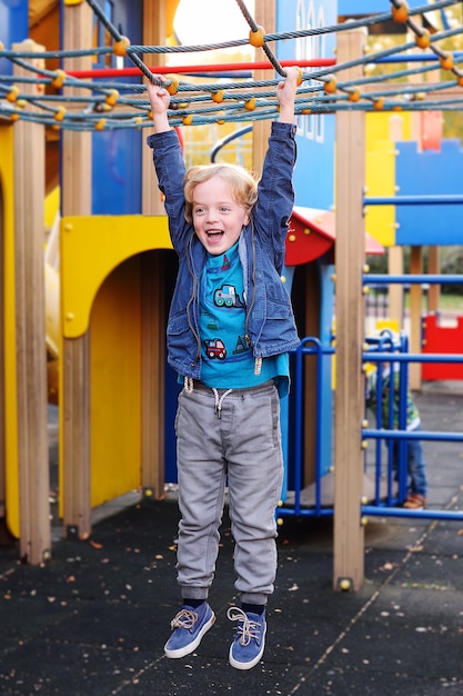 Bebe Garcon Aux Cheveux Boucles Jouant Sur L Aire De Jeux Dans Le Parc D Attractions Photo Premium