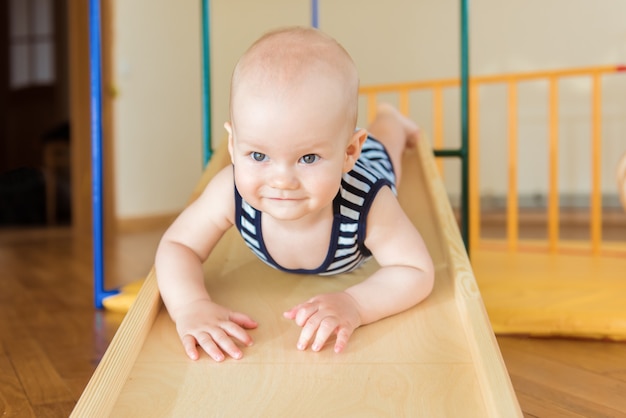 Bebe Mignon Effectue Des Exercices De Gymnastique Sur Un Complexe Sportif A Domicile En Bois Escaliers Et Anneaux Photo Premium