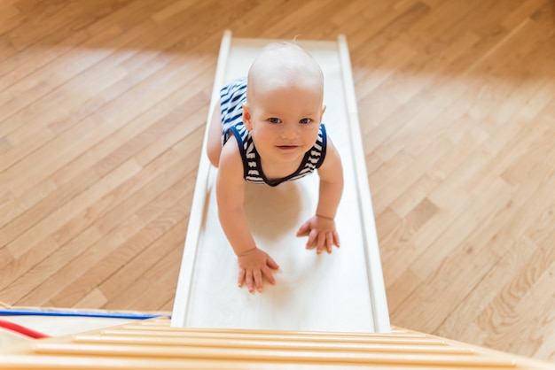 Bebe Mignon Effectue Des Exercices De Gymnastique Sur Un Complexe Sportif A Domicile En Bois Photo Premium